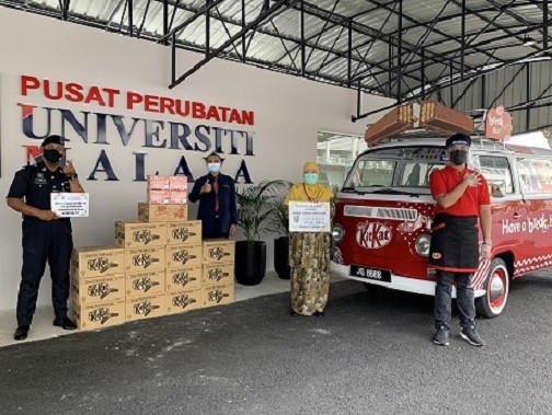 Representatives from Pusat Perubatan Universiti Malaya (PPUM) receiving product donations from KITKAT