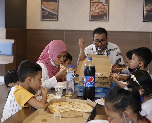 Yusrizal and his family were treated to a scrumptious pizza meal at the Domino's store