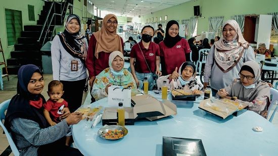 Representatives from Sime Darby Oils with residents of Al-Mahmudah Center during their visit